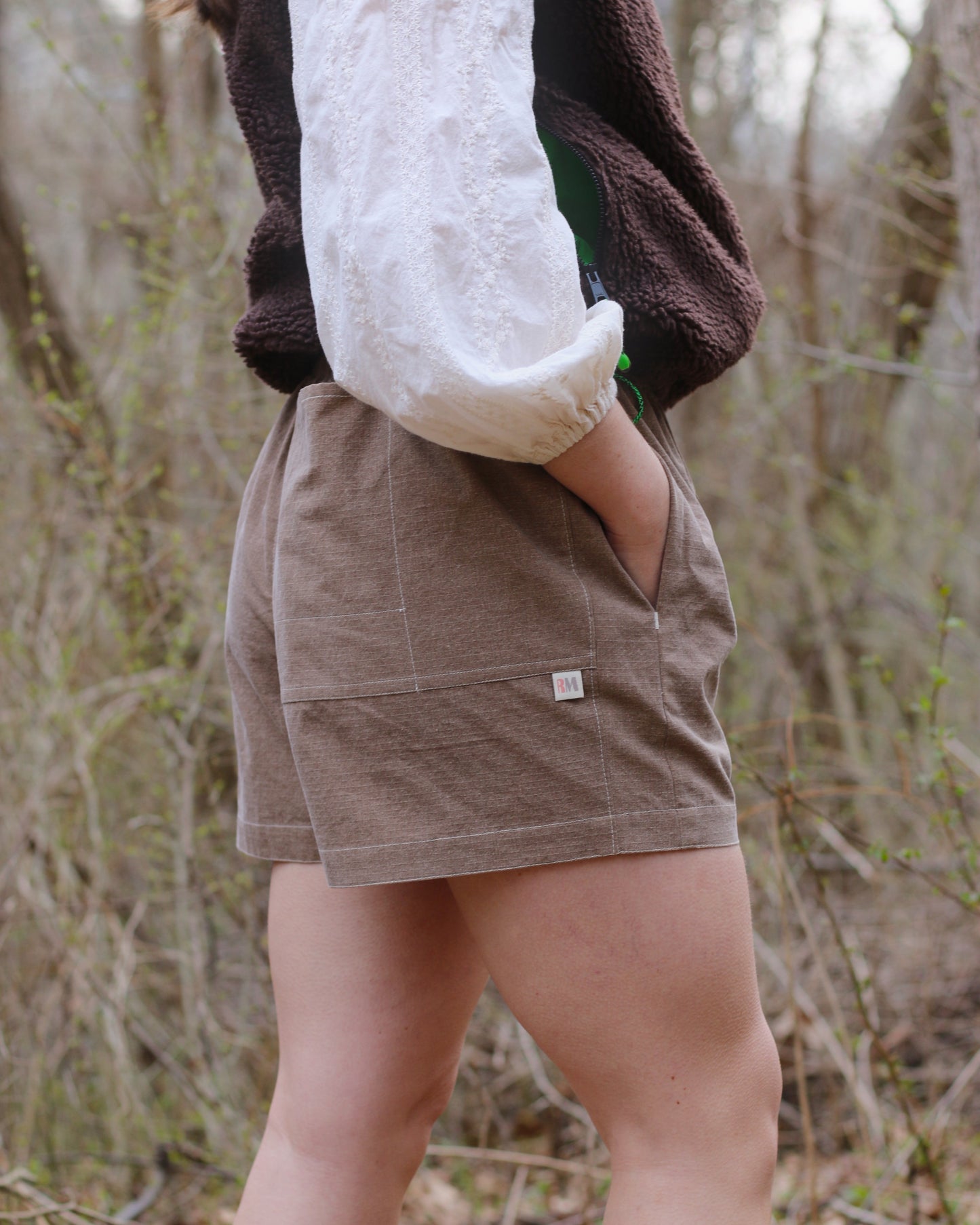 Women in brown shorts with hand in front pocket